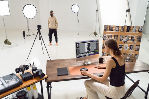 A photographer editing product photos in a studio