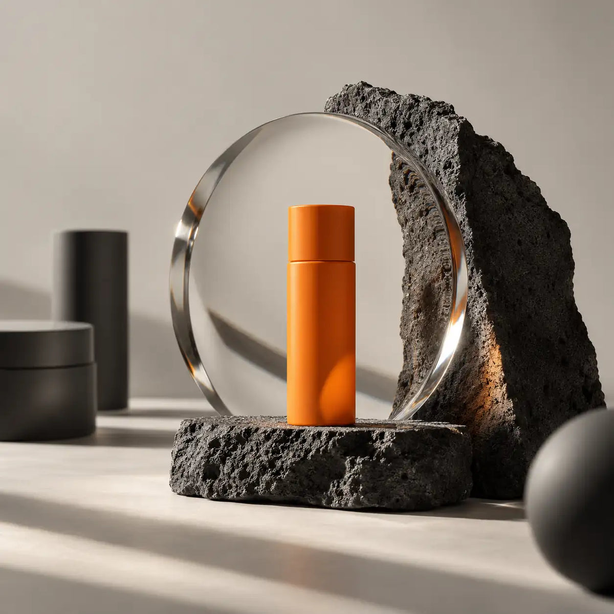 Orange product bottle seen through an optical glass disc on dark stone